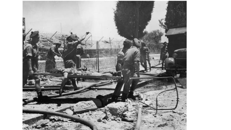 جنود بريطانيون زميلهم المصاب من بين أنقاض فندق الملك داود الذي تم تفجيره من قبل إرهابيين من جماعة أرعون، 26 يوليو/ تموز 1946