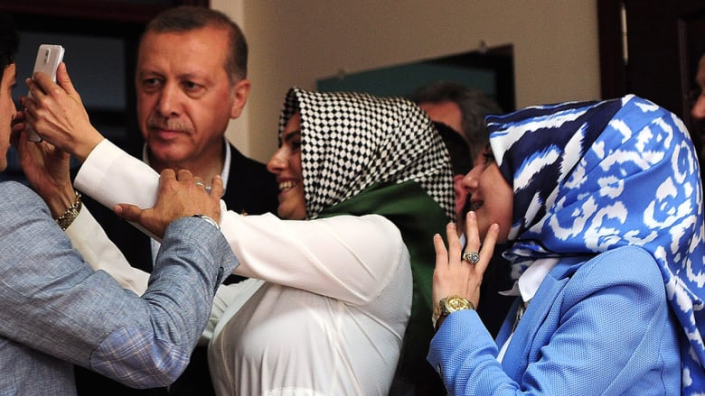 مسؤولة انتخابية تأخذ صورة "سيلفي" مع الرئيس التركي رجب طيب اردوغان بعد ادلائه بصوته في الانتخابات التشريعية باسطنبول في 7 يونيو 2015