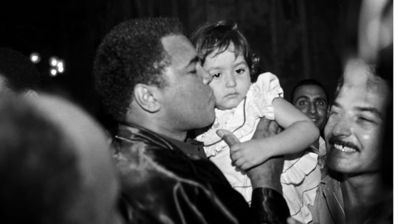 محمد علي يقبل طفلا بعد أداء الصلاة 