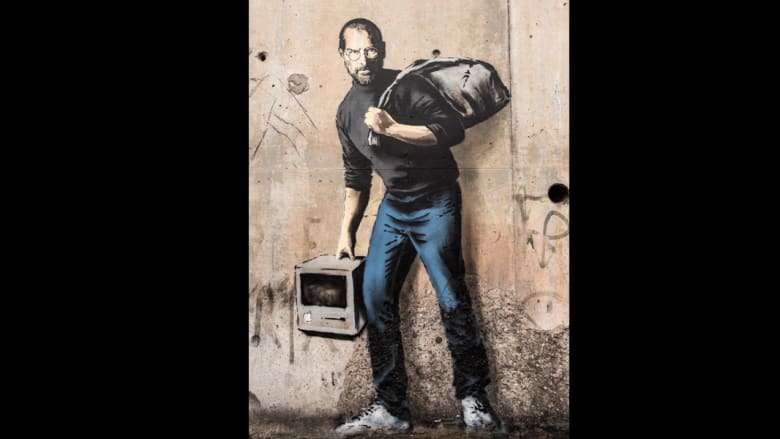 جدارية جديدة للفنان بانكسي تصور ستيف جوبز "لاجئاً" في مخيم للاجئين السوريين 