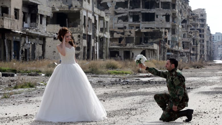 بالصور.. جندي سوري وعروسه يلتقطان صور زفافهما التذكارية وسط الدمار بحلب 