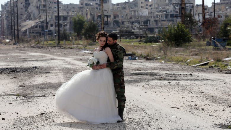 بالصور.. جندي سوري وعروسه يلتقطان صور زفافهما التذكارية وسط الدمار بحلب 