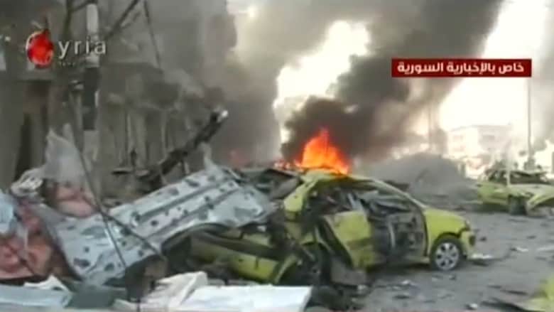 بالفيديو.. اثار التفجير المزدوج الذي راح ضحيته 25 شخصاً بمنطقة الزهراء في حمص