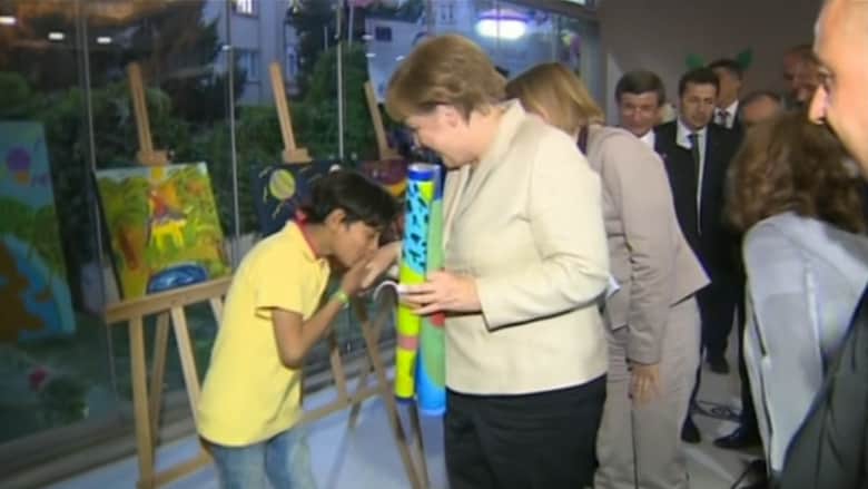 بالفيديو: طفل يقبل يد ميركل خلال زيارتها إلى مخيم للاجئين السوريين في تركيا