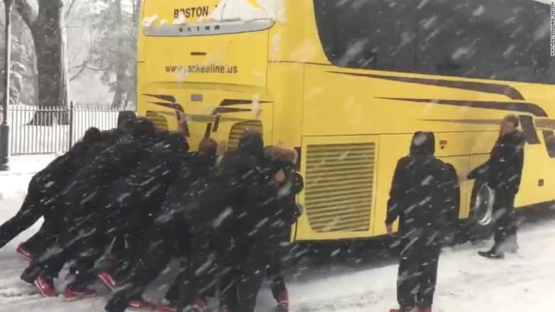 شاهد.. فتيات يدفعن حافلة علقت في الثلج