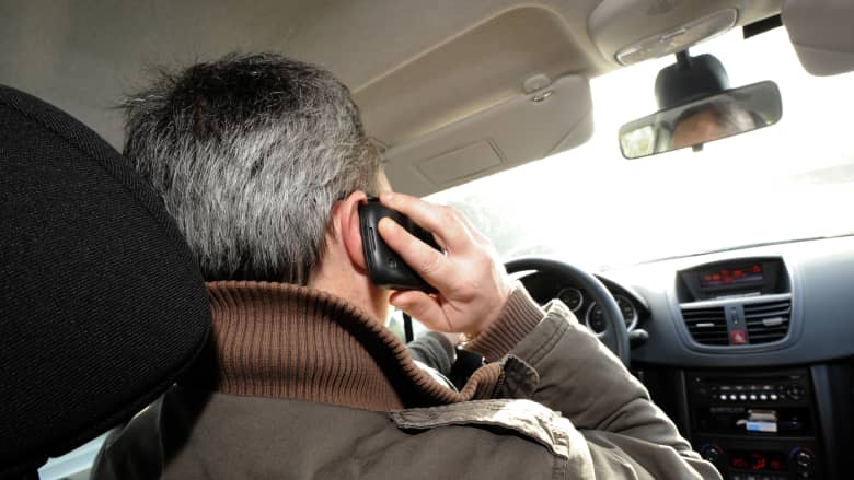 صورة لشخص يستخدم الهاتف أثناء قيادة مركبة