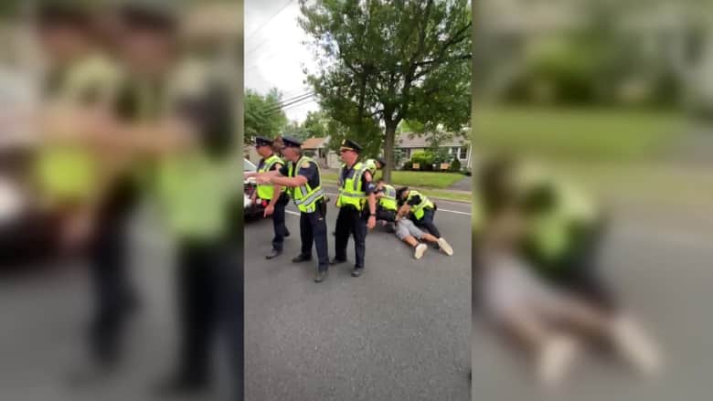 ضباط الشرطة يدفعون رجلا أسود إلى الأرض والمتظاهرون يتدخلون
