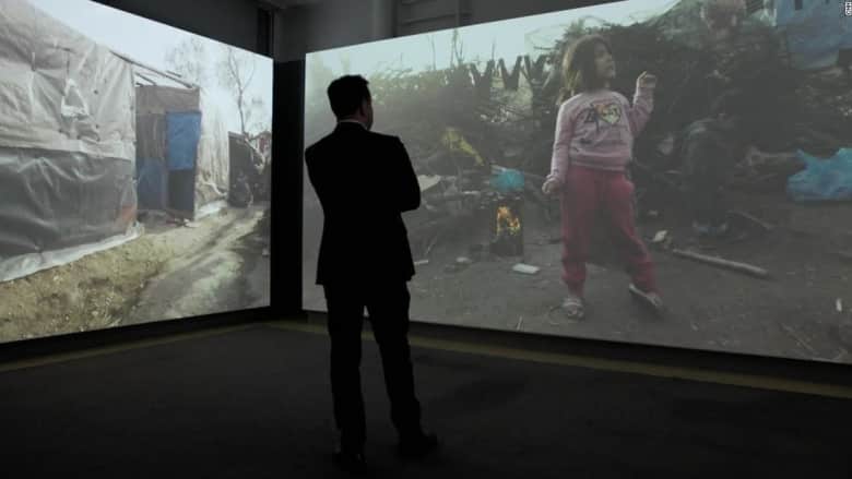 شاهد.. "آلة الزمن" داخل معرض تجعلك تسير في مخيم موريا للاجئين قبل الكارثة