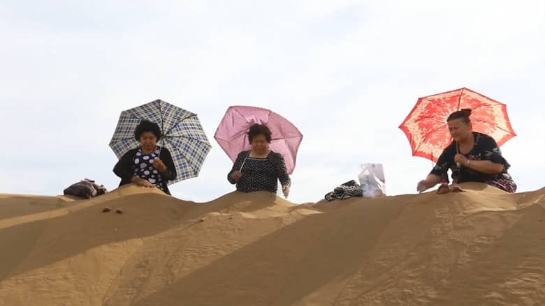 السياح في الصين يتدفقون على الكثبان الرملية "للاستحمام بالرمل"