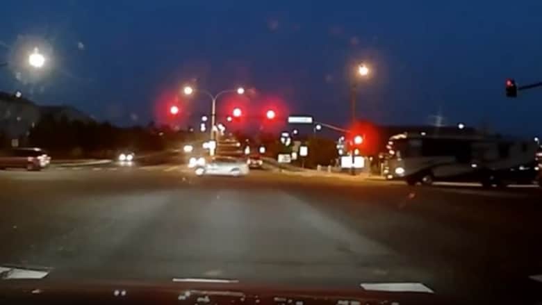رجل يجتاز إشارة المرور ويقفز من سيارته ليمنع أخرى دون سائق من التسبب في حادث