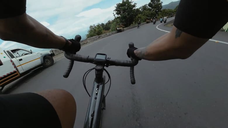 مغامر يقود دراجته أسفل ممر جبلي في الهند