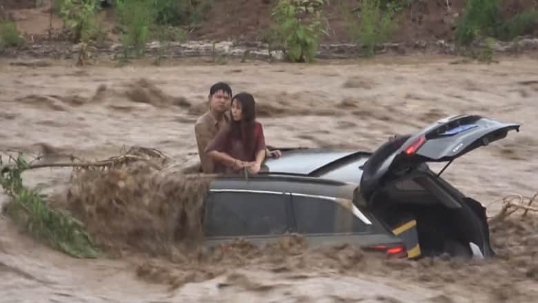 لحظات عصيبة.. شاهد عملية إنقاذ دراماتيكية لزوجين علقا فوق سيارتهما بسبب الفيضانات