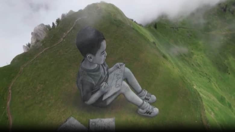 شاهد.. فنان يرسم لوحات جدارية ضخمة على جبال سويسرا