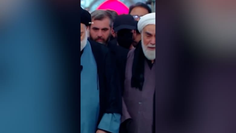 قبعة سوداء وقناع يثيران تساؤلات.. من هو الغامض الذي لفت الأنظار بجنازة خامنئي؟