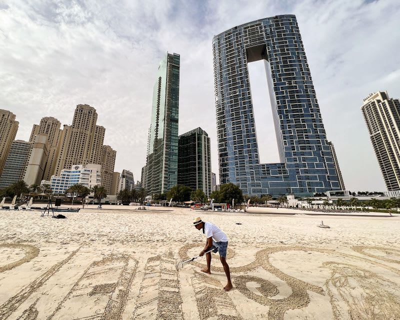 فنان فلبيني يحوّل شواطئ دبي الرملية إلى لوحات فنية