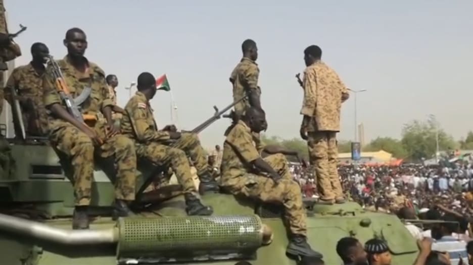 جنود سودانيون يقفون مع متظاهرين بالقرب من مقر الجيش بالخرطوم