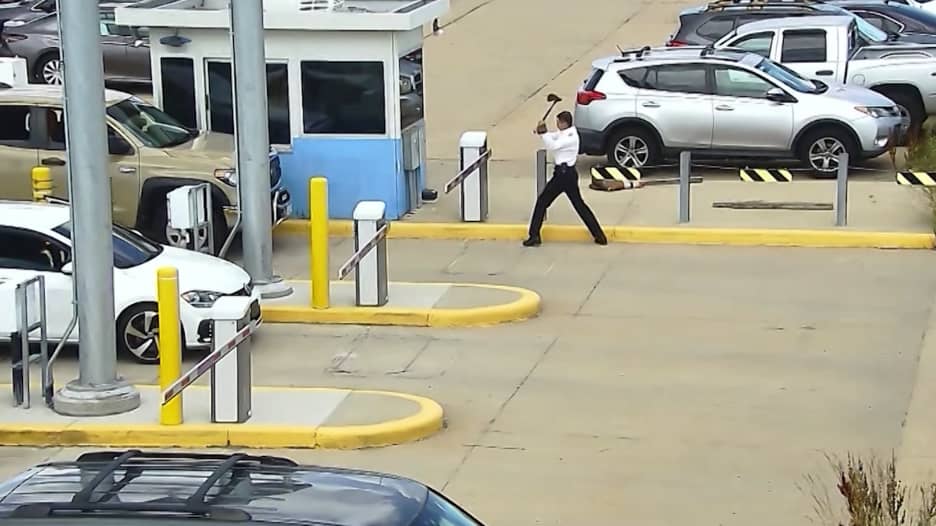 مسلحًا بفأس.. كاميرا تكشف تصرفًا غريبًا لطيّار داخل موقف للسيارات بمطار أمريكي
