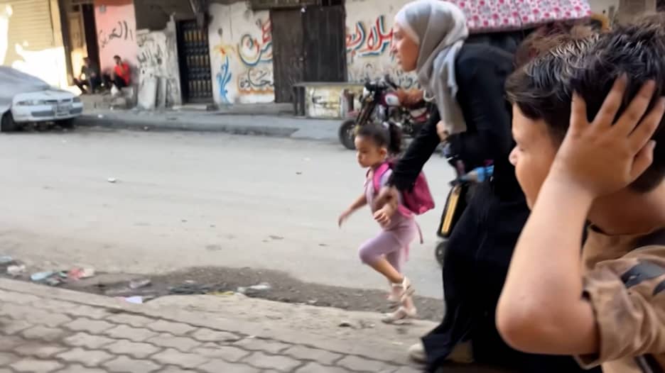 خوف يسود شوارع غزة.. شاهد ما حدث لحظة فرار أم مع طفليها وسط طلقات نارية