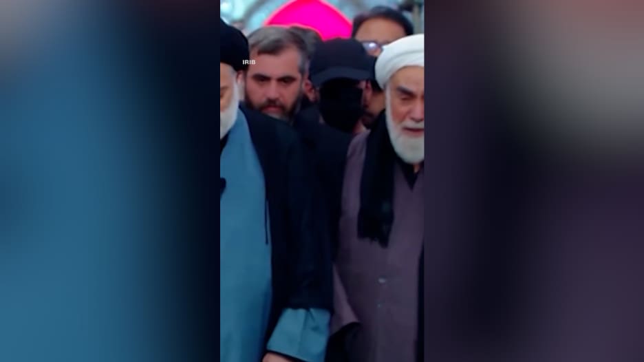 قبعة سوداء وقناع يثيران تساؤلات.. من هو الغامض الذي لفت الأنظار بجنازة خامنئي؟