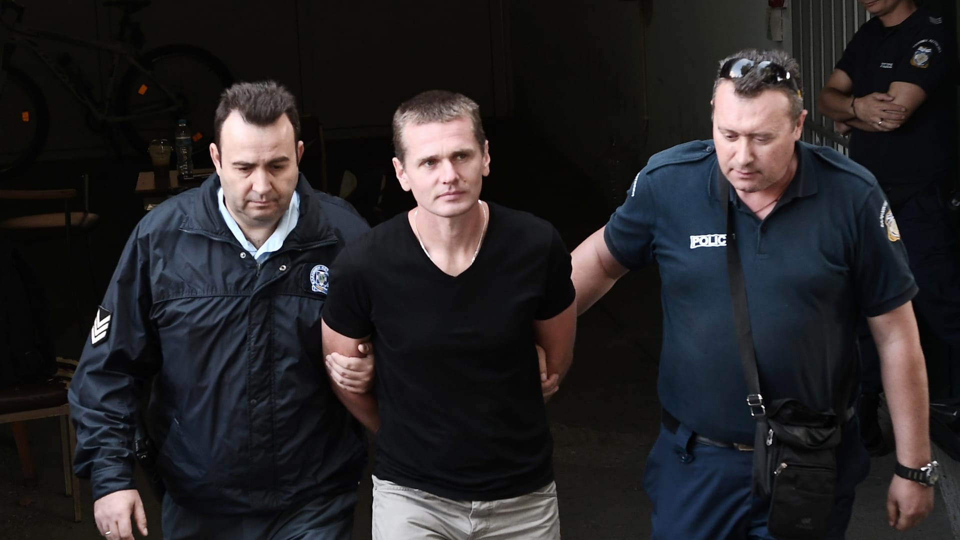 فردين من الشرطة اليونانية يمسكان بألكسندر فينيك 
