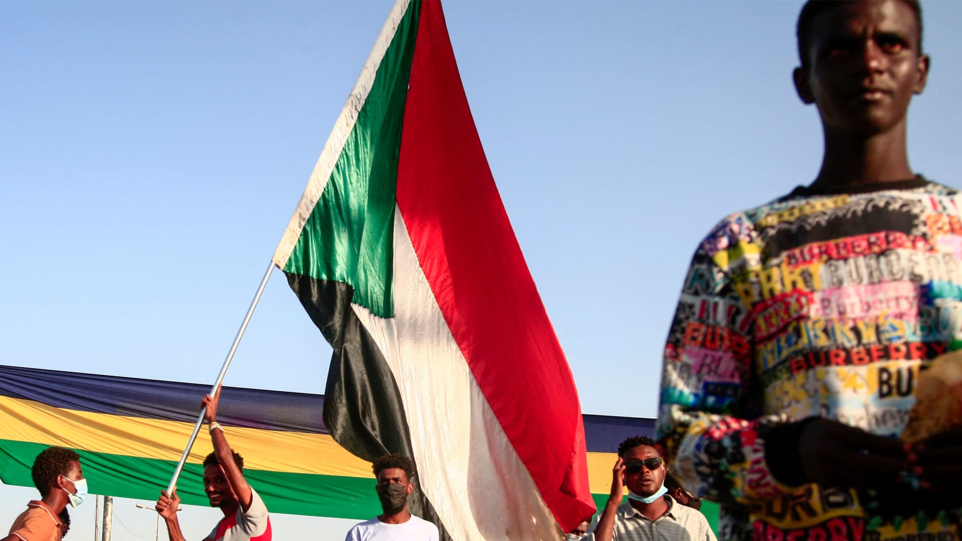 صورة أرشيفية لمتظاهرين سودانيين يرفعون علم بلادهم 