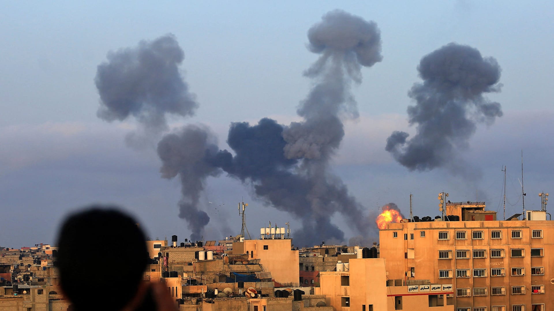 طفل فلسطيني يشاهد الدخان يتصاعد من أهداف خلال الغارات الجوية الإسرائيلية على خان يونس جنوب غزة