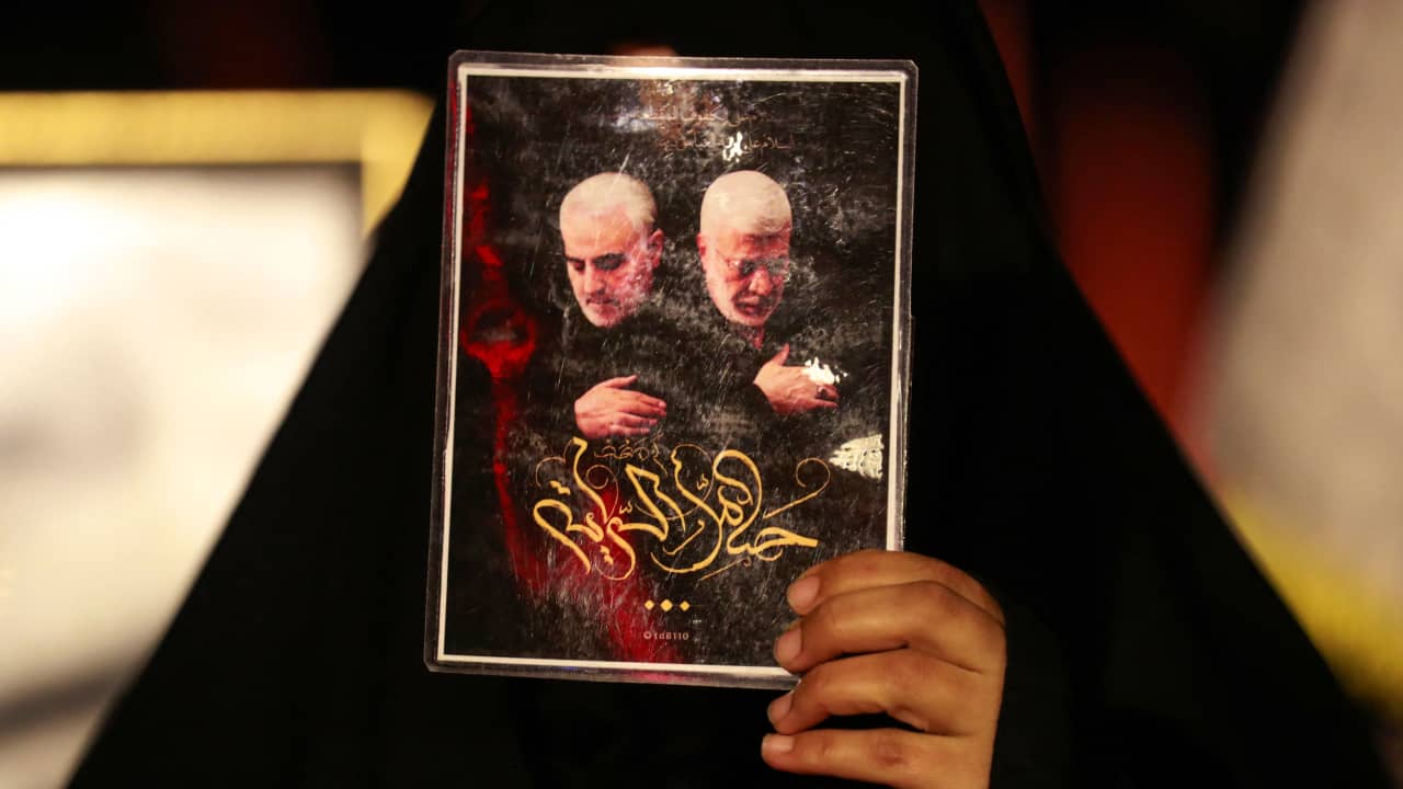 عراقية ترفع صورة لقاسم سليماني وأبومهدي المهندس خلال حفل تأبين أقيم بمناسبة الذكرى الثانية لمقتلهما