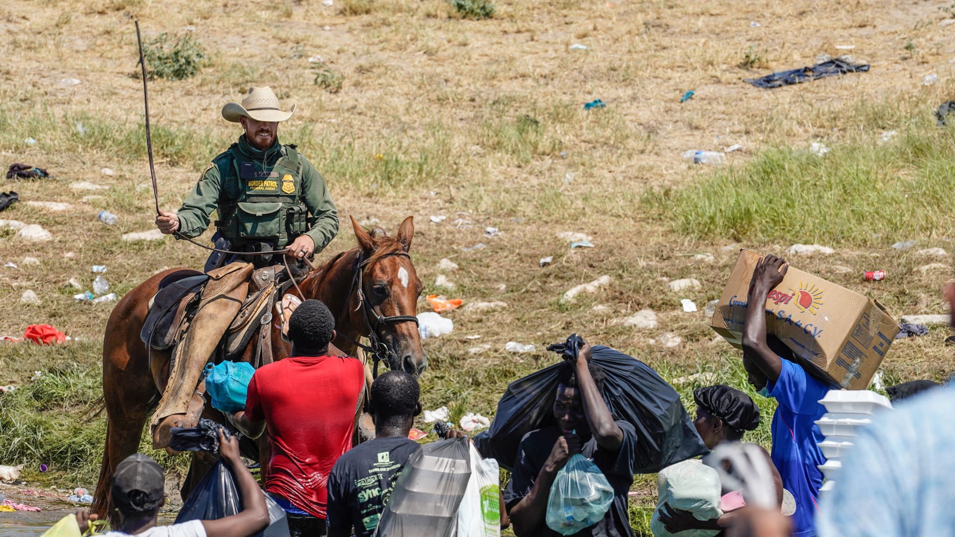   دوريات الحدود بالولايات المتحدة على ظهور الخيل في مواجهة المهاجرين الهايتيين على ضفاف نهر ريو غراندي بولاية تكساس - 19 سبتمبر 2021.