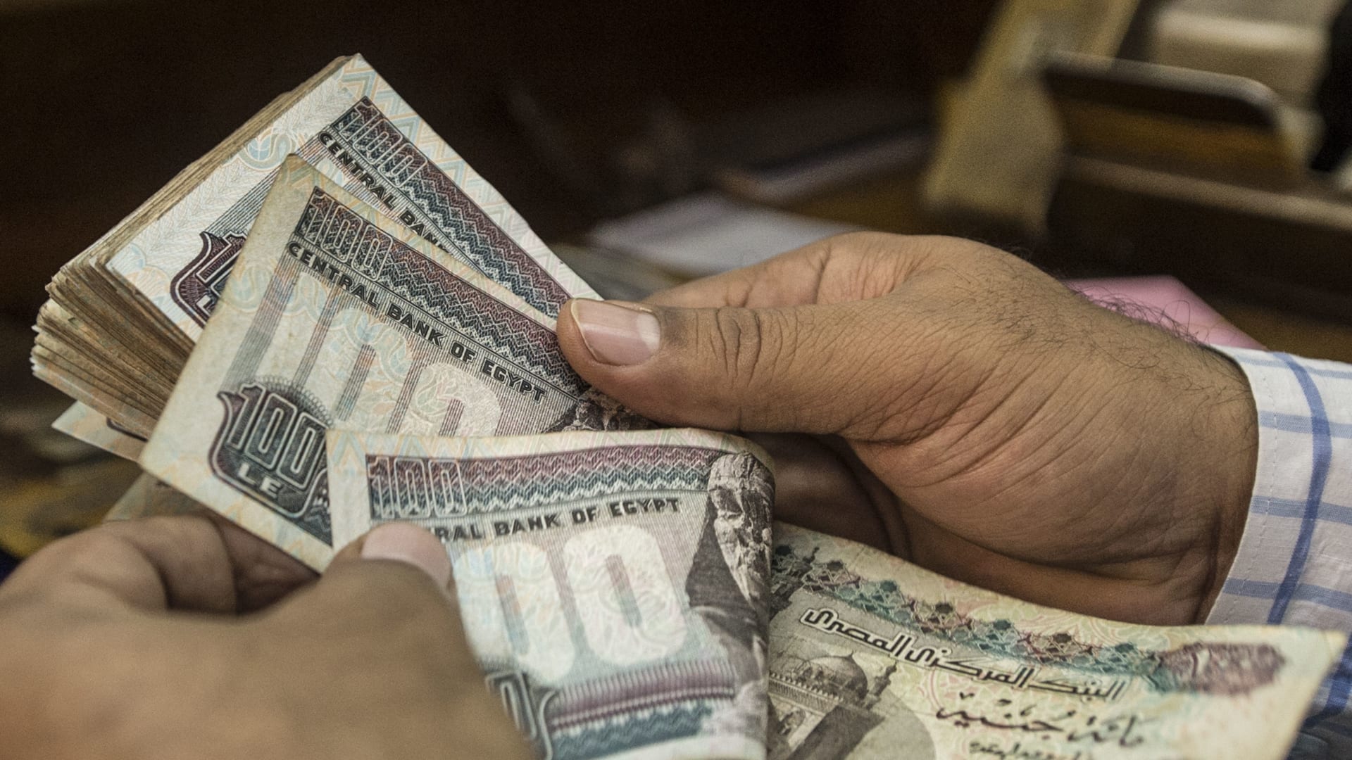 رجل يعد جنيهات مصرية في محل صرافة بالقاهرة