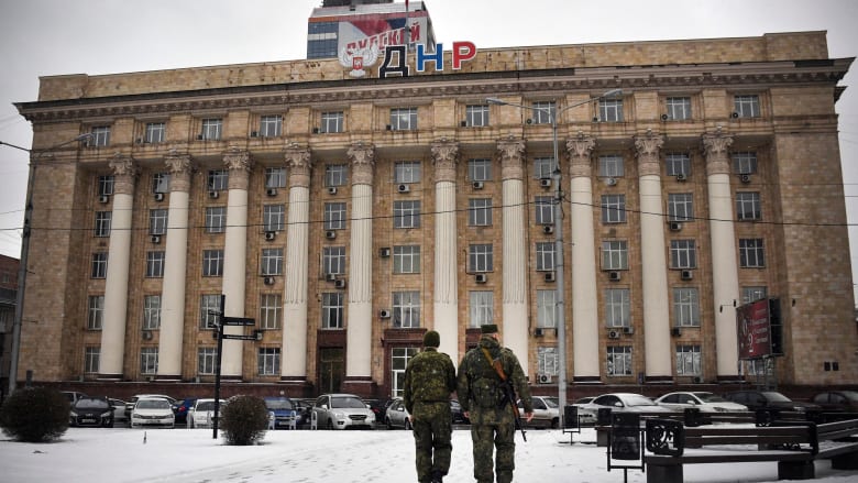 مسلحان من الميليشيات الانفصالية في دونيتسك يسيران بجوار مبنى "مجلس الشعب" 