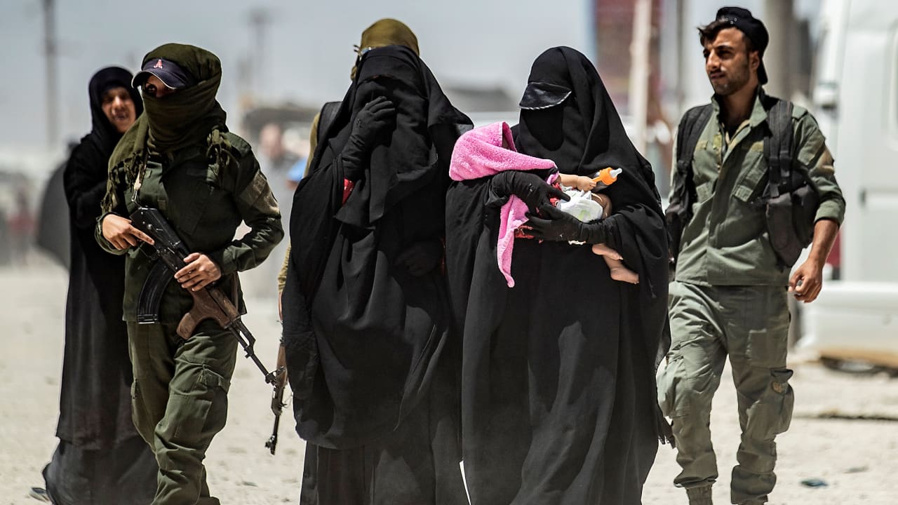 حراس في مخيم الهول بمحافظة الحسكة السورية مع زوجات مقاتلي تنظيم داعش 