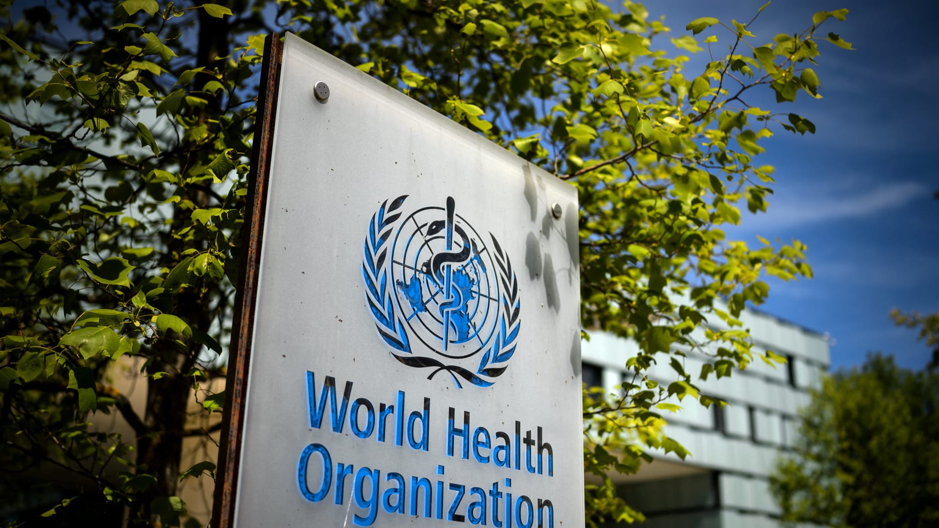 لافتة تحمل اسم وشعار منظمة الصحة العالمية في مدخل مبنى المنظمة بجنيف