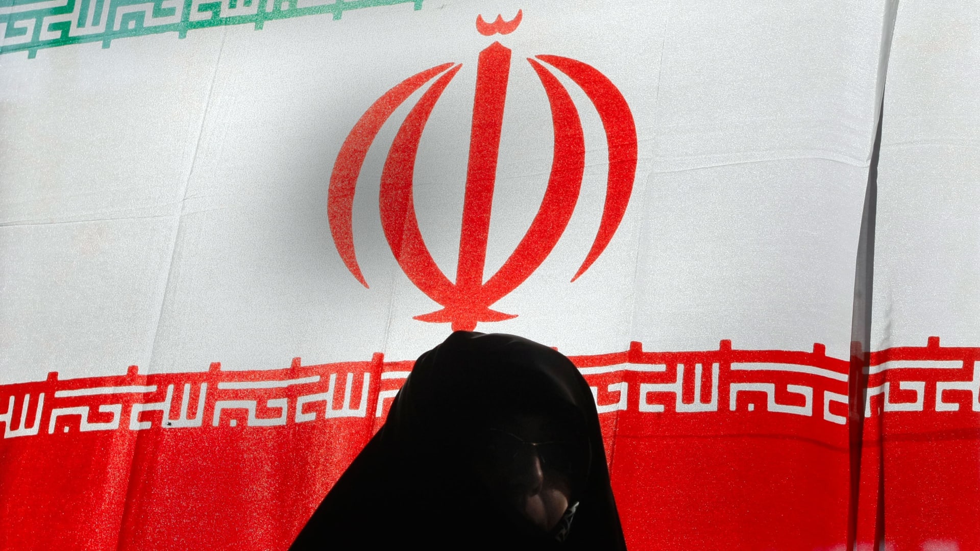 إيرانية تسير أمام علم بلادها في طهران 