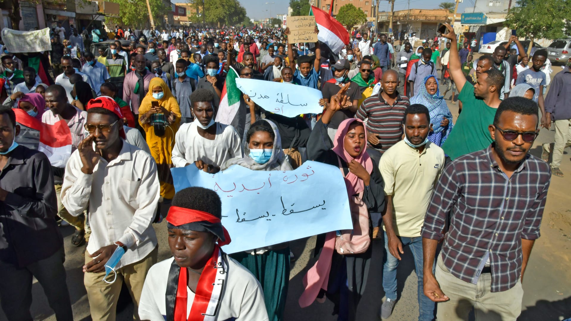 متظاهرون سودانيون يرفعون لافتات وأعلام خلال مظاهرة تطالب بعودة الحكم المدني في أم درمان