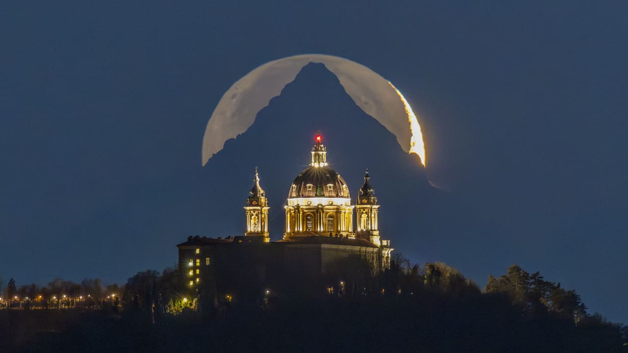 موعد لا يُنسى..إيطالي يوثق لحظة سحرية للقمر خلف قمة جبل فيزو
