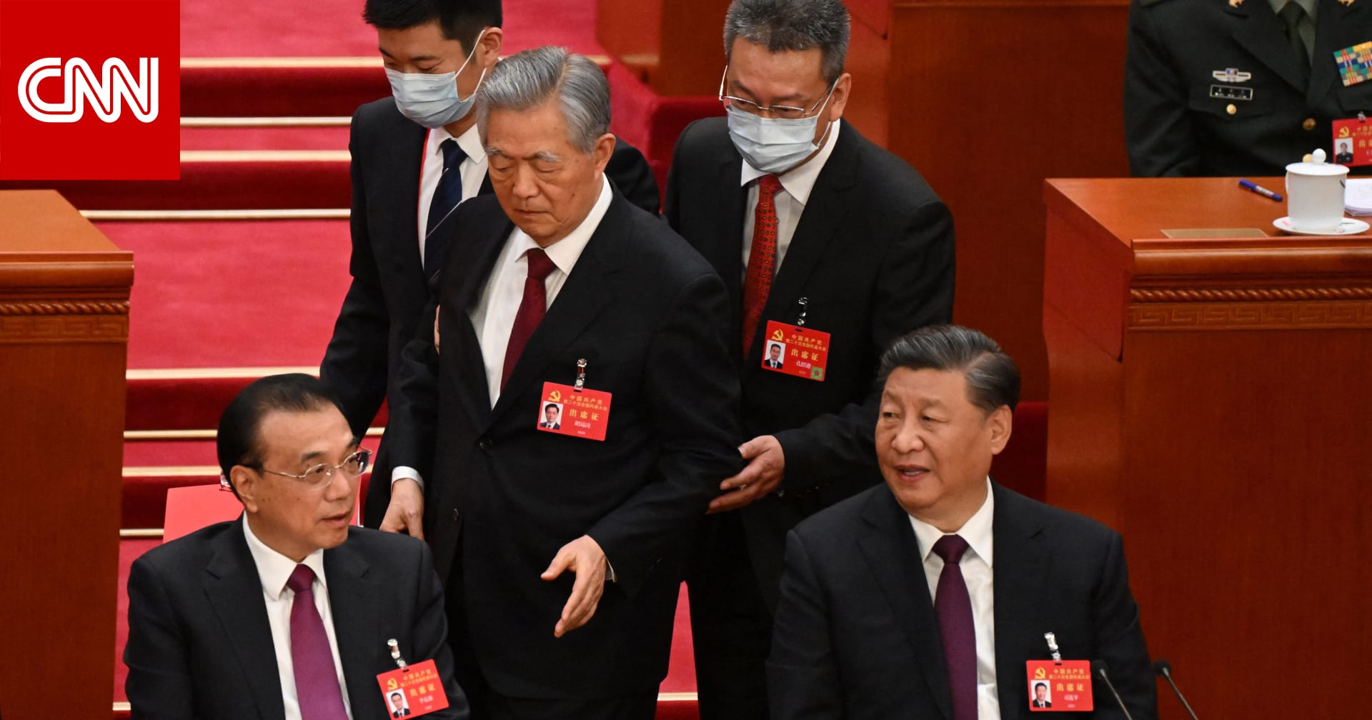 كان يجلس بجانب شي جين بينغ رجلان يقودان رئيس الصين السابق إلى خارج