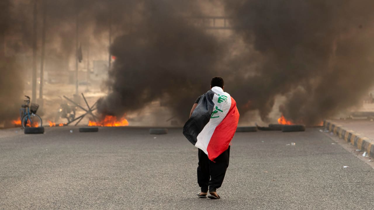 أحد أنصار رجل الدين الشيعي العراقي مقتدى الصدر يحمل العلم العراقي  خلال مظاهرة في مدينة البصرة