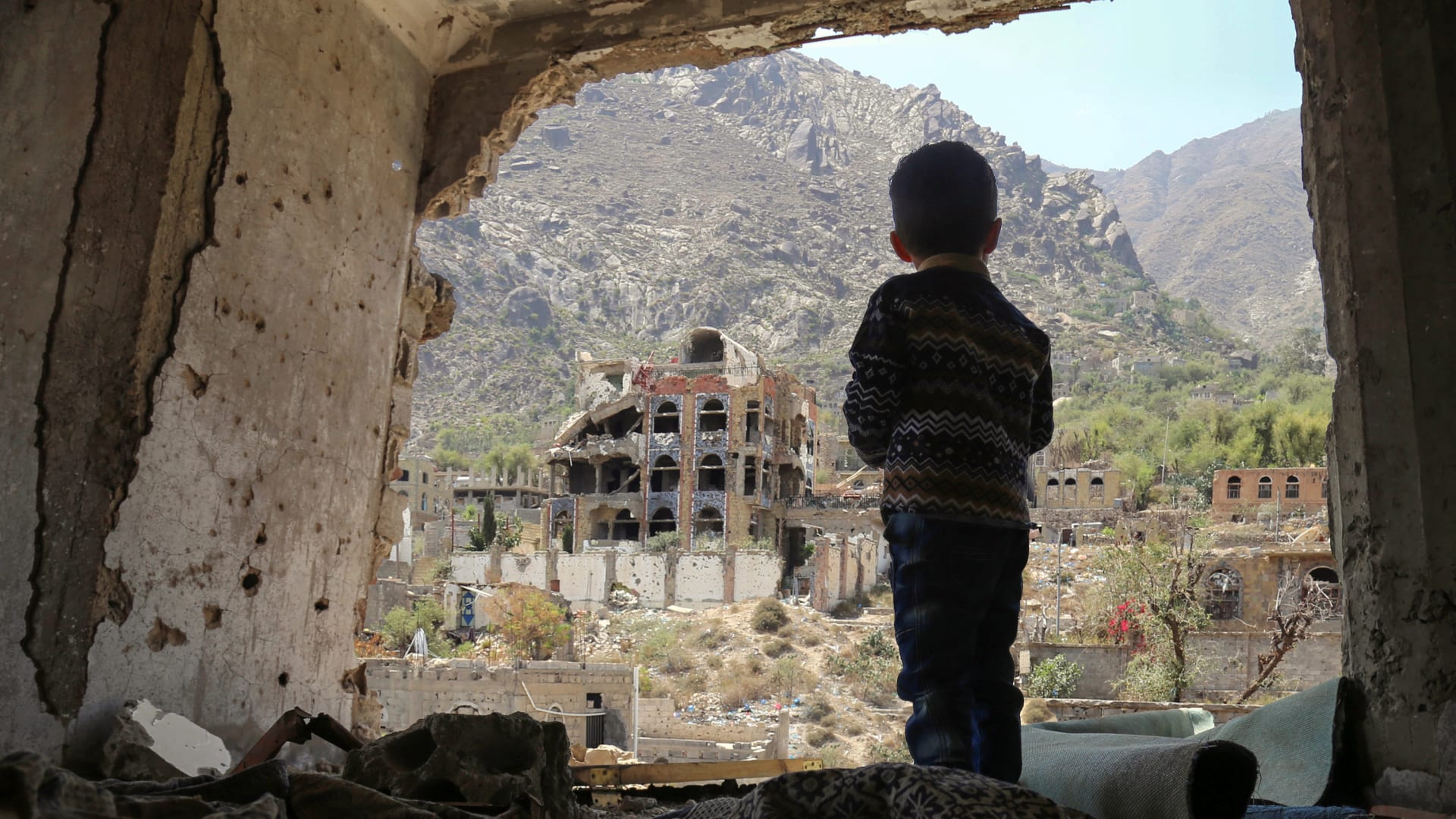 طفل ينظر إلى المباني المهدمة في مدينة تعز اليمنية 
