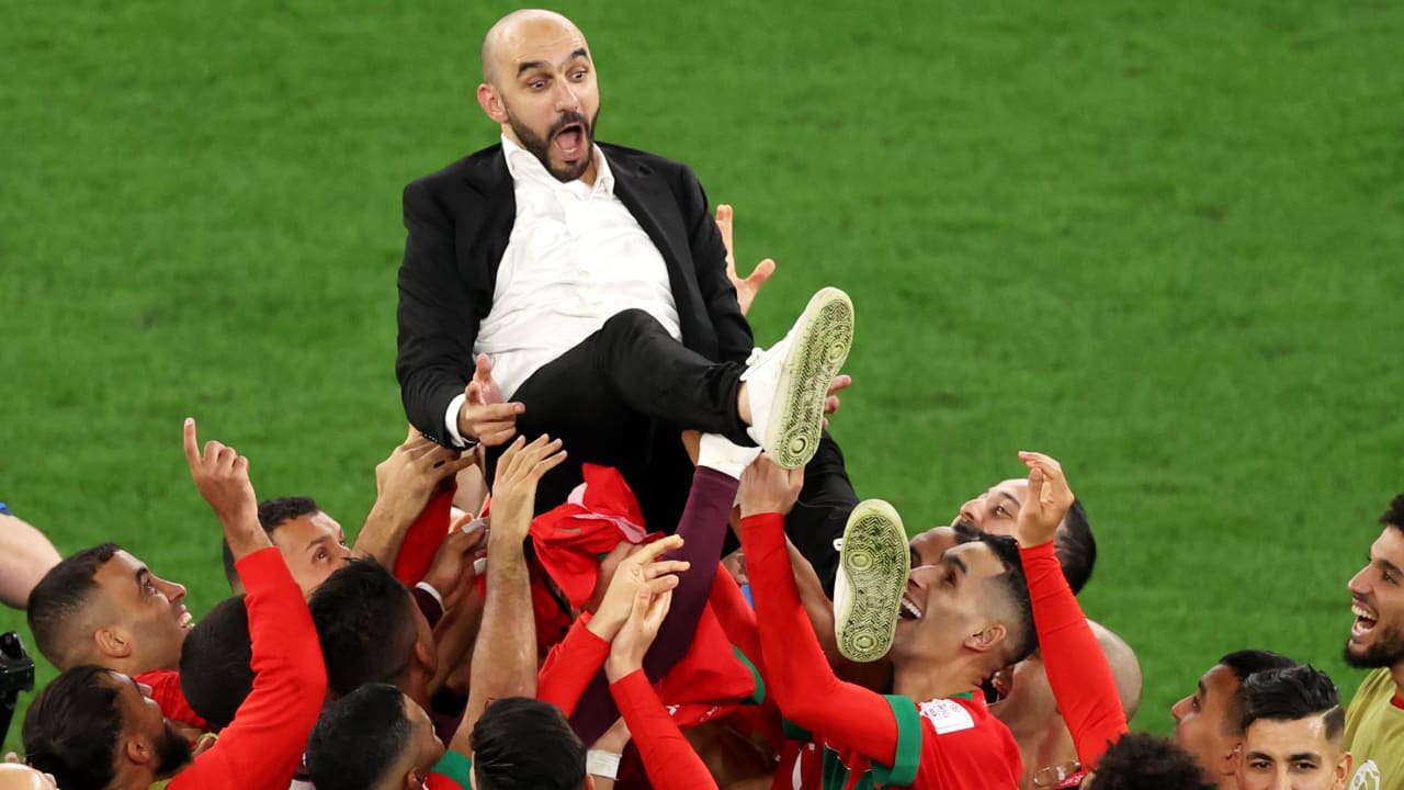 لاعبو المغرب يحتفلون مع مدربهم بعد فوزهم على إسبانيا في مونديال قطر 